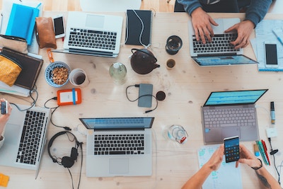 Studenten am Schreibtisch mit Laptops, die Kursinhalte vorbereiten